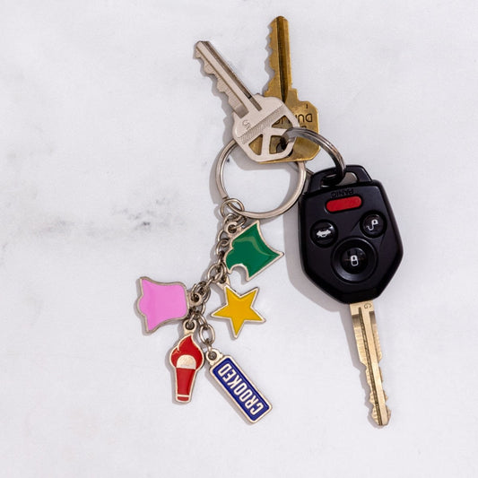 Keychain with various charms attached to keys on a light gray background
