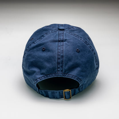 Blue denim cap with a gold buckle on a light gray background