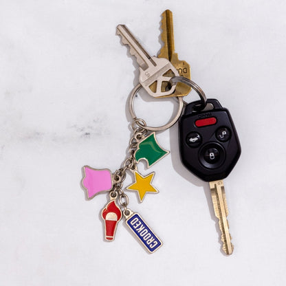 Keychain with various charms attached to keys on a light gray background