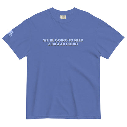 A blue short-sleeve crewneck t-shirt with the text 'WE'RE GOING TO NEED A BIGGER COURT' printed in light blue white across the chest